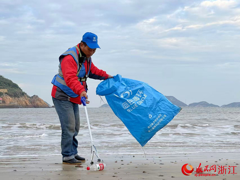 “小蓝之家”的工作人员在海滩捡拾塑料垃圾。人民网记者 郭扬摄