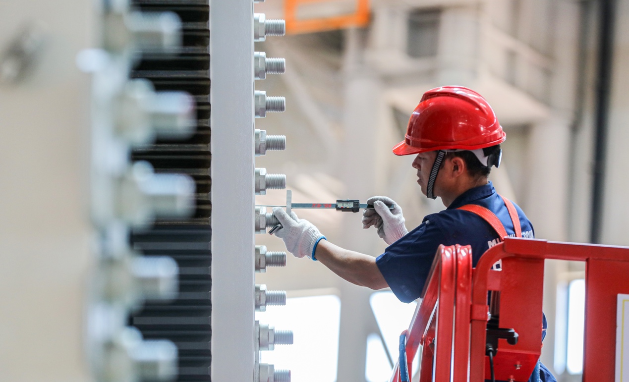 工人拧紧关键螺栓,保障设备安装精度。乳山市委宣传部供图