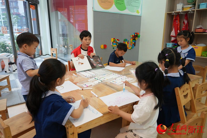 “共享奶奶”周玲珍正在为孩子们讲绘本。人民网 陈陆洵摄